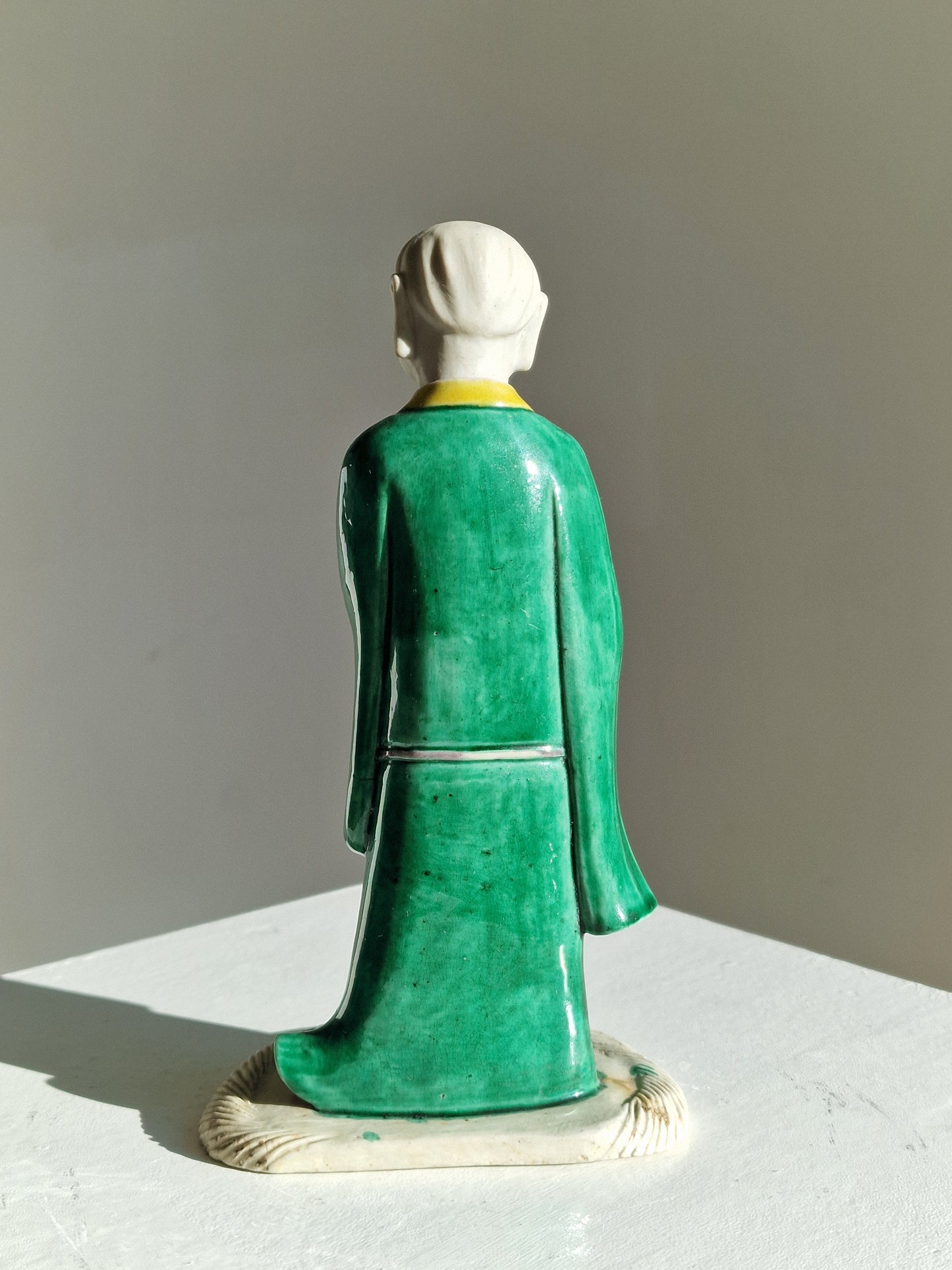 A Chinese sancai-glazed biscuit figure of a Luohan holding a ruyi — Kangxi period (1662–1722)