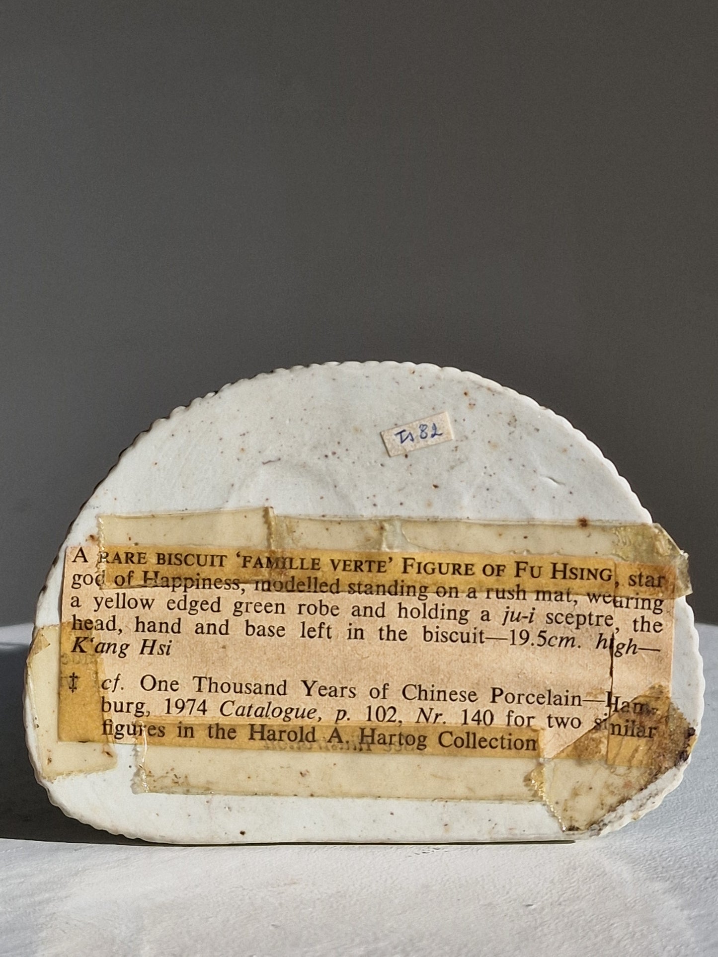 A Chinese sancai-glazed biscuit figure of a Luohan holding a ruyi — Kangxi period (1662–1722)