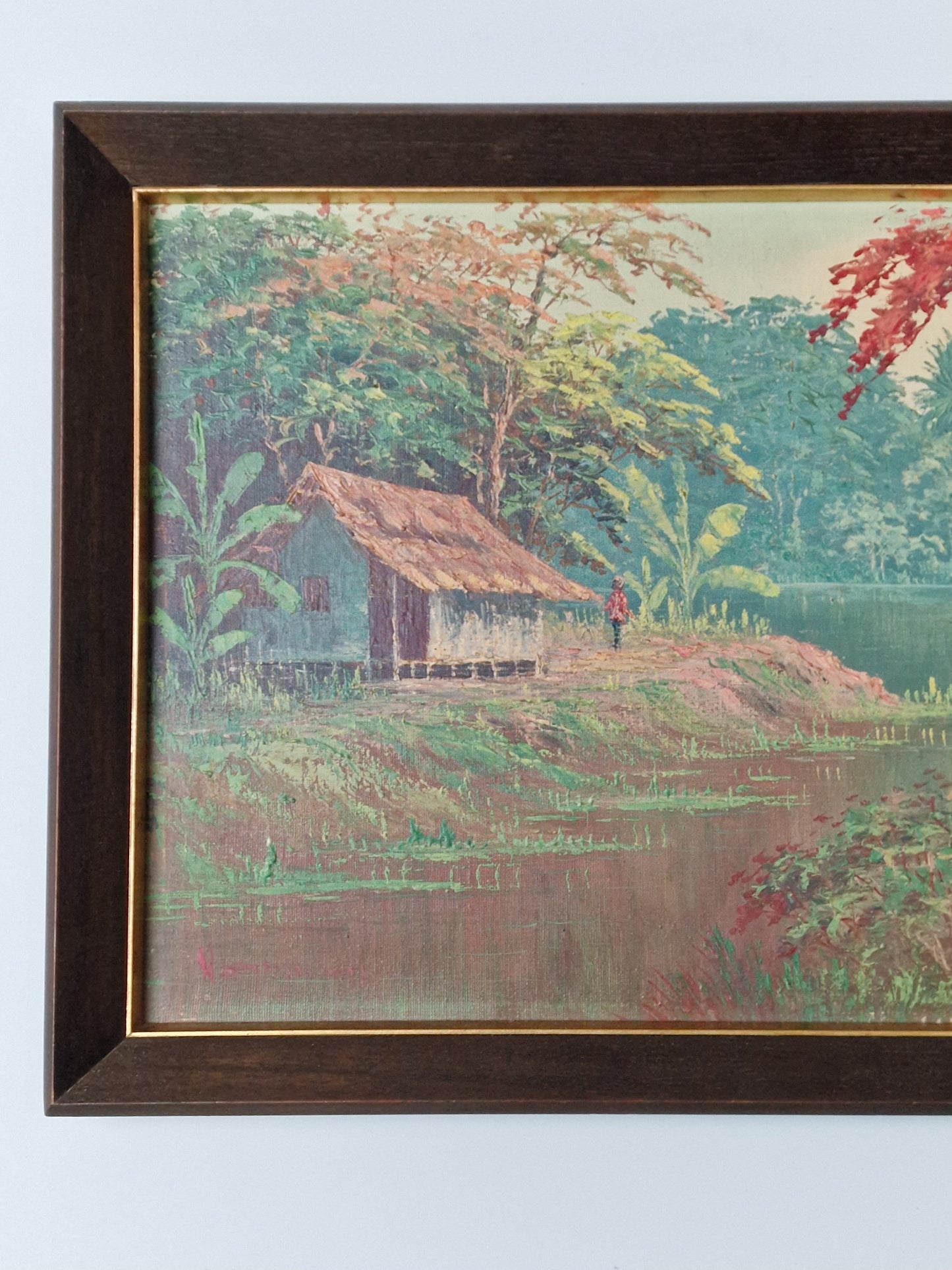 A Tropical river landscape oil painting with stilted house and a flame tree — mid-20th century