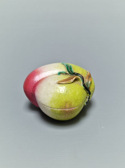 A Chinese famille rose porcelain covered box in the form of a peach — Qing Dynasty, 19th century