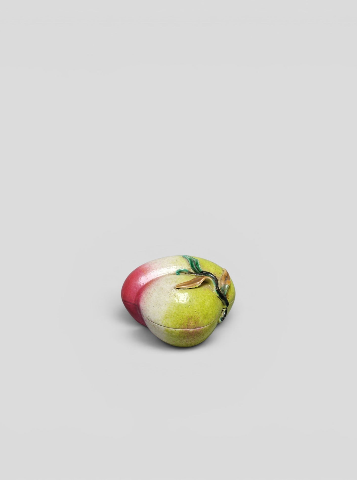 A Chinese famille rose porcelain covered box in the form of a peach — Qing Dynasty, 19th century