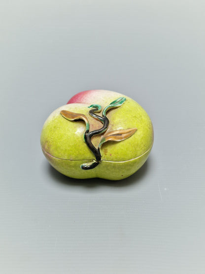 A Chinese famille rose porcelain covered box in the form of a peach — Qing Dynasty, 19th century