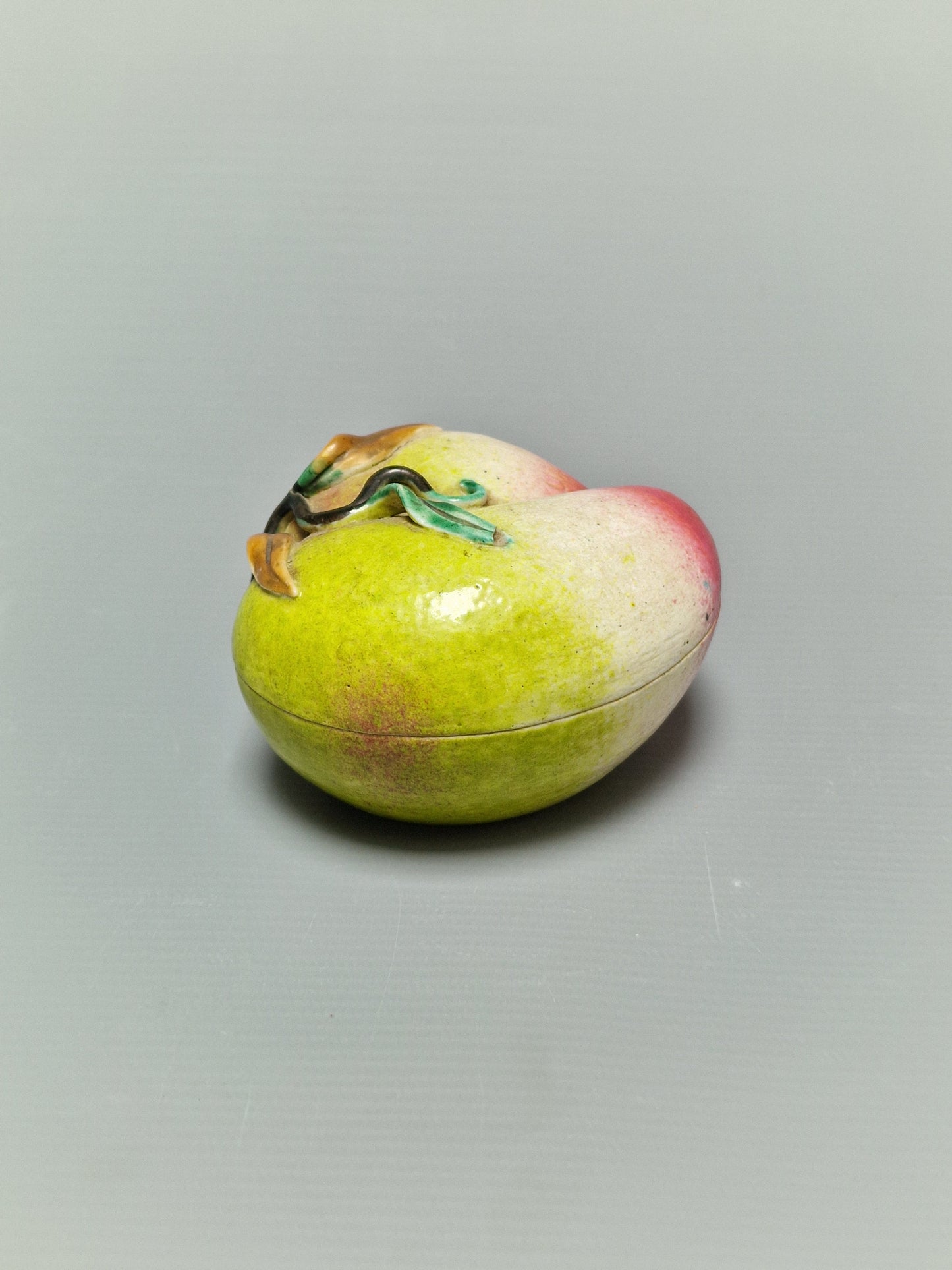 A Chinese famille rose porcelain covered box in the form of a peach — Qing Dynasty, 19th century