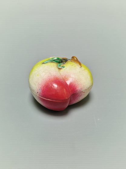 A Chinese famille rose porcelain covered box in the form of a peach — Qing Dynasty, 19th century