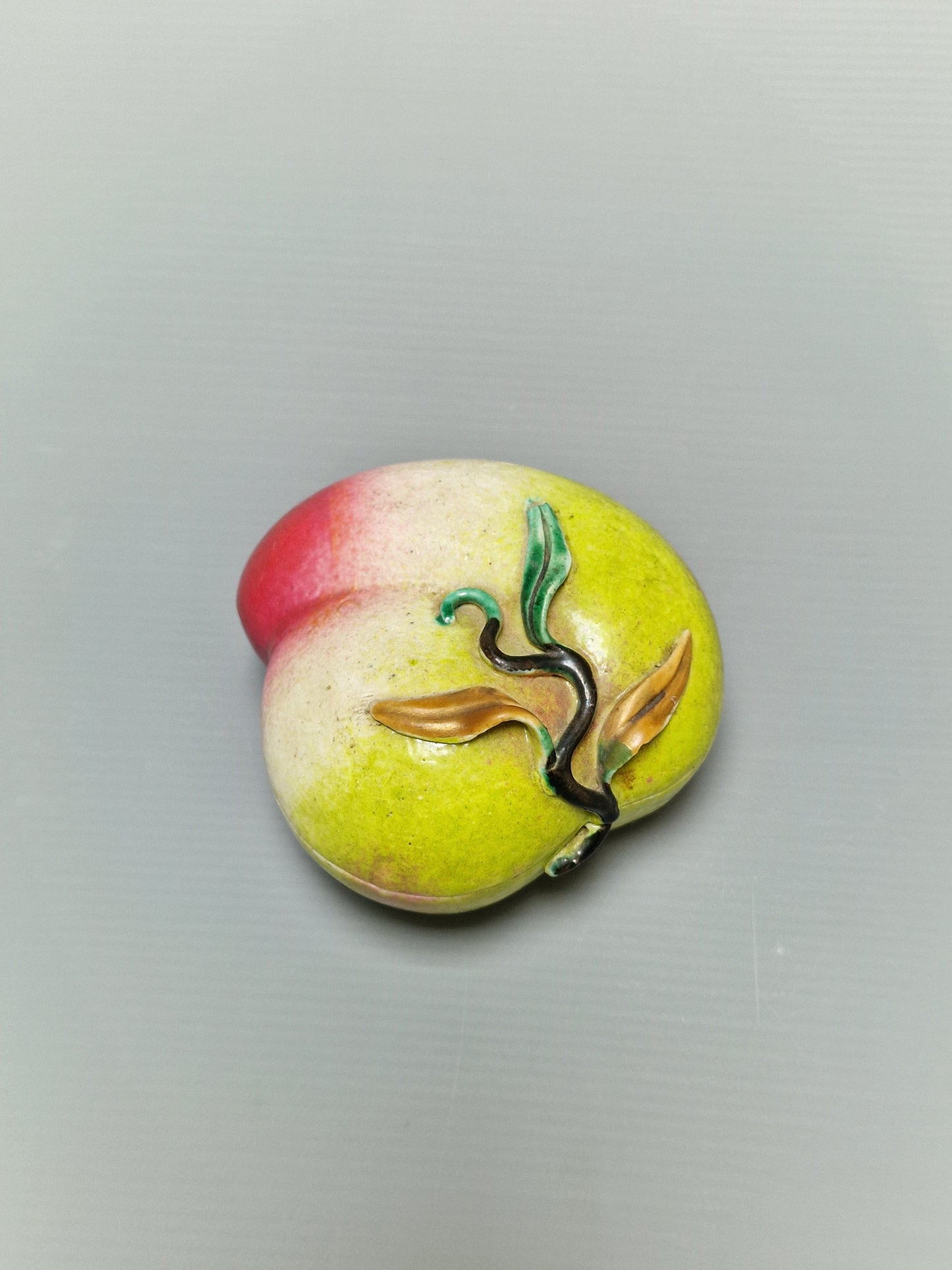 A Chinese famille rose porcelain covered box in the form of a peach — Qing Dynasty, 19th century