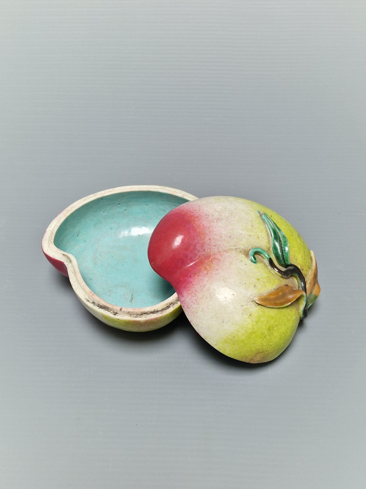 A Chinese famille rose porcelain covered box in the form of a peach — Qing Dynasty, 19th century