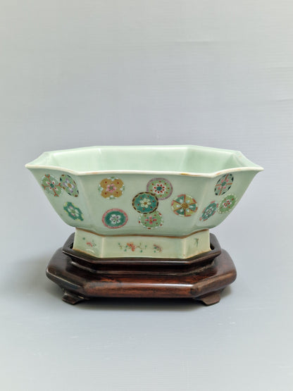 A Chinese octagonal famille rose celadon-ground 'Brocade Balls' offering bowl on a wooden stand, bearing a Daoguang mark, 19th century