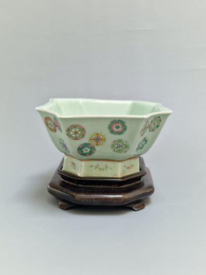 A Chinese octagonal famille rose celadon-ground 'Brocade Balls' offering bowl on a wooden stand, bearing a Daoguang mark, 19th century
