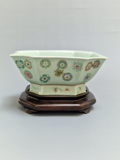 A Chinese octagonal famille rose celadon-ground 'Brocade Balls' offering bowl on a wooden stand, bearing a Daoguang mark, 19th century