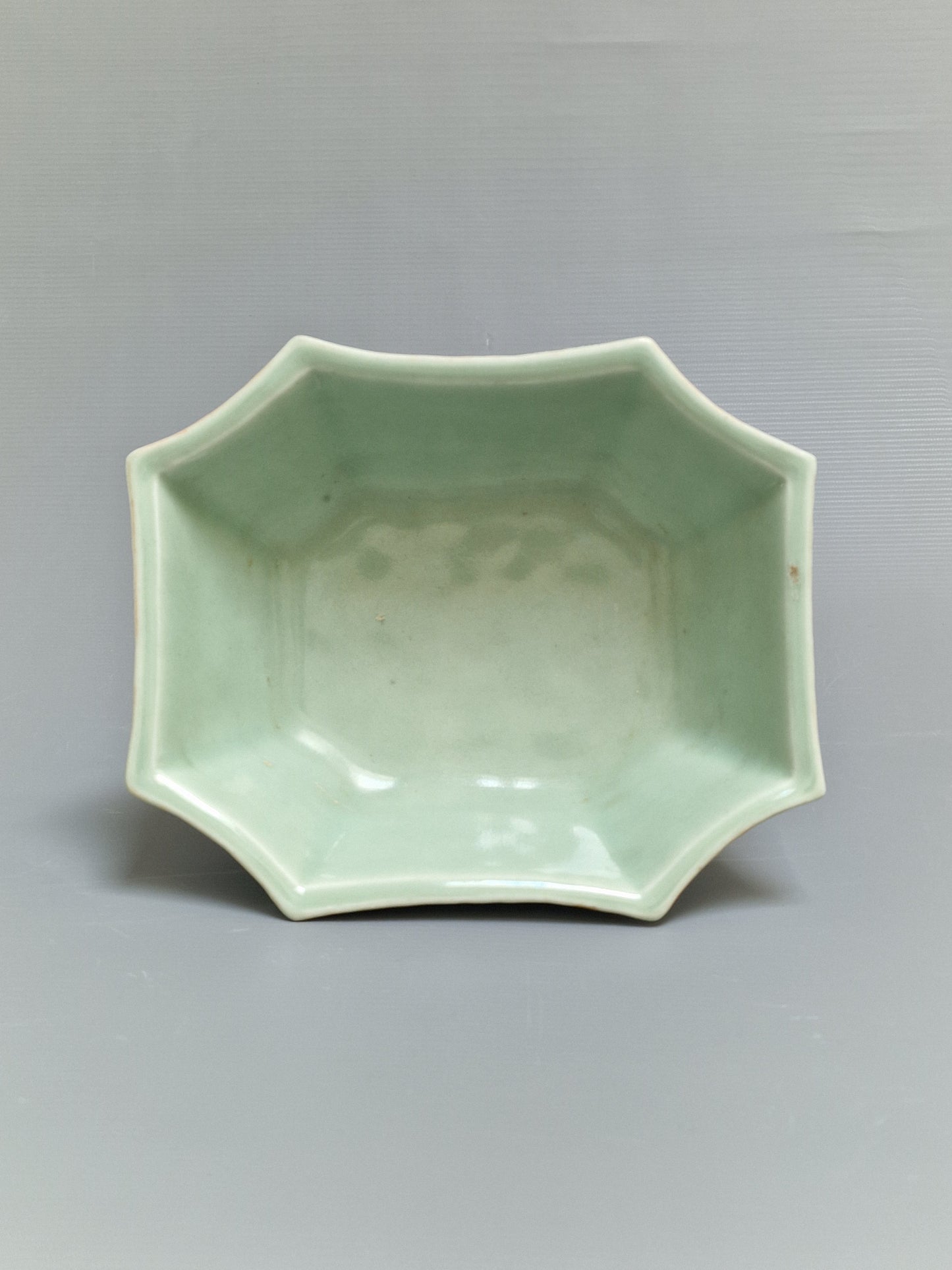 A Chinese octagonal famille rose celadon-ground 'Brocade Balls' offering bowl on a wooden stand, bearing a Daoguang mark, 19th century