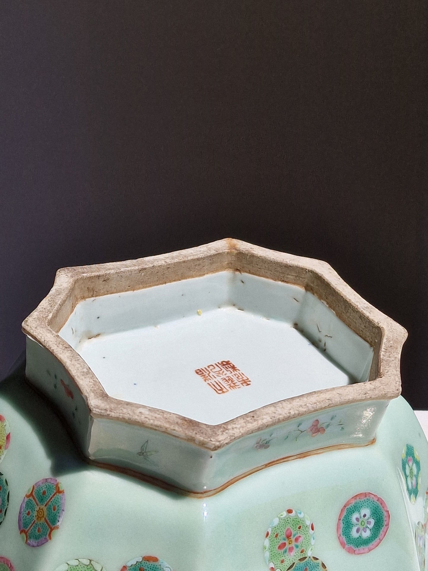 A Chinese octagonal famille rose celadon-ground 'Brocade Balls' offering bowl on a wooden stand, bearing a Daoguang mark, 19th century