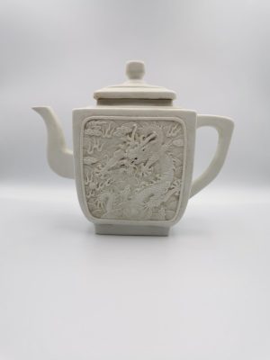A Chinese Biscuit porcelain teapot carved with dragons on both sides, late 19th century