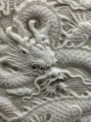 A Chinese Biscuit porcelain teapot carved with dragons on both sides, late 19th century