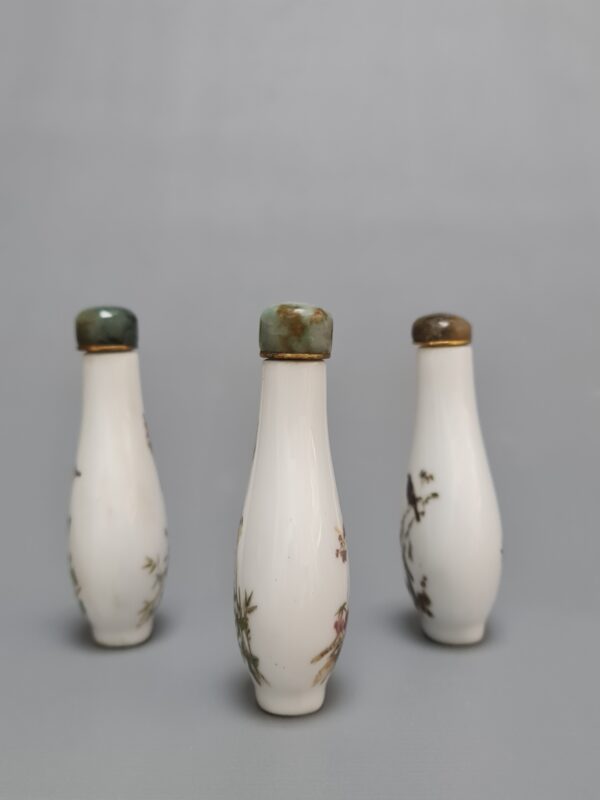 Three Chinese Famille Rose porcelain snuff bottles with green stone stoppers, featuring floral and bird motifs on both sides. - Afbeelding 2