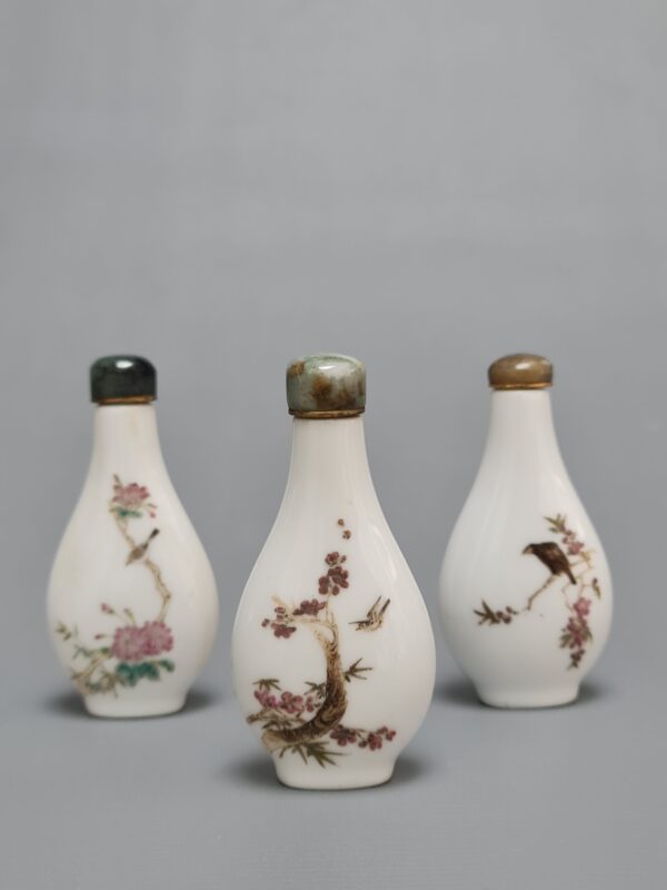 Three Chinese Famille Rose porcelain snuff bottles with green stone stoppers, featuring floral and bird motifs on both sides. - Afbeelding 3
