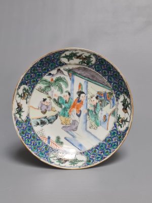 A Chinese porcelain Famille Verte plate depicting a garden and  shopping scene,  Daoguang period (1821-1850)