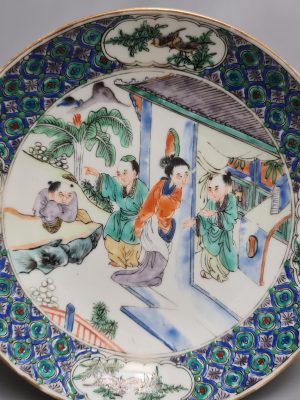 A Chinese porcelain Famille Verte plate depicting a garden and  shopping scene,  Daoguang period (1821-1850)