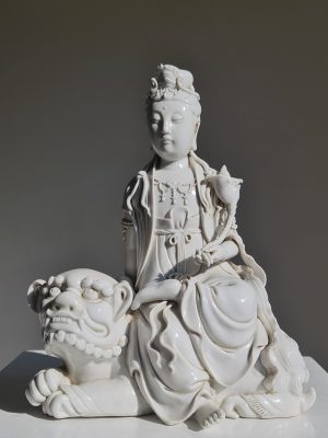 A Chinese Dehua figure of Manjushri seated on a lion, Qing Dynasty (1644-1911)